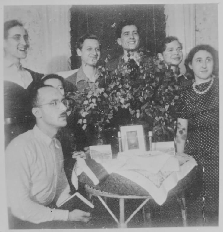 Mitglieder of Chug Chalutzi feiern Schawuot im Haus von Gad Beck / Members of Chug Chalutzi celebrate Shavuot at the home of Gad Beck. von links/ from left: Gad Beck, Yizchak Schwersenz, Edith (Ewo) Wolff (hidden), Zwi Aviram (Abrahamssohn), Poldi Chones, David Billard, Miriam Beck, Juni 1943, Quelle: United States Holocaust Memorial Museum